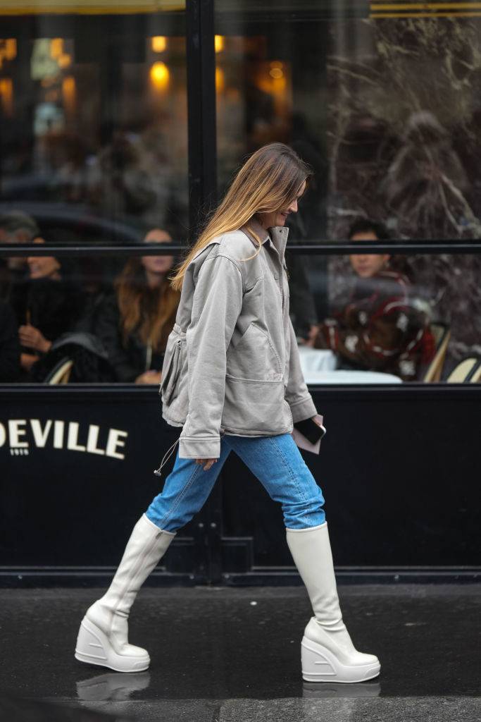 Wąskie jeansy do białych kozaków na koturnie w stylu ulicznym. (Fot. Getty Images)