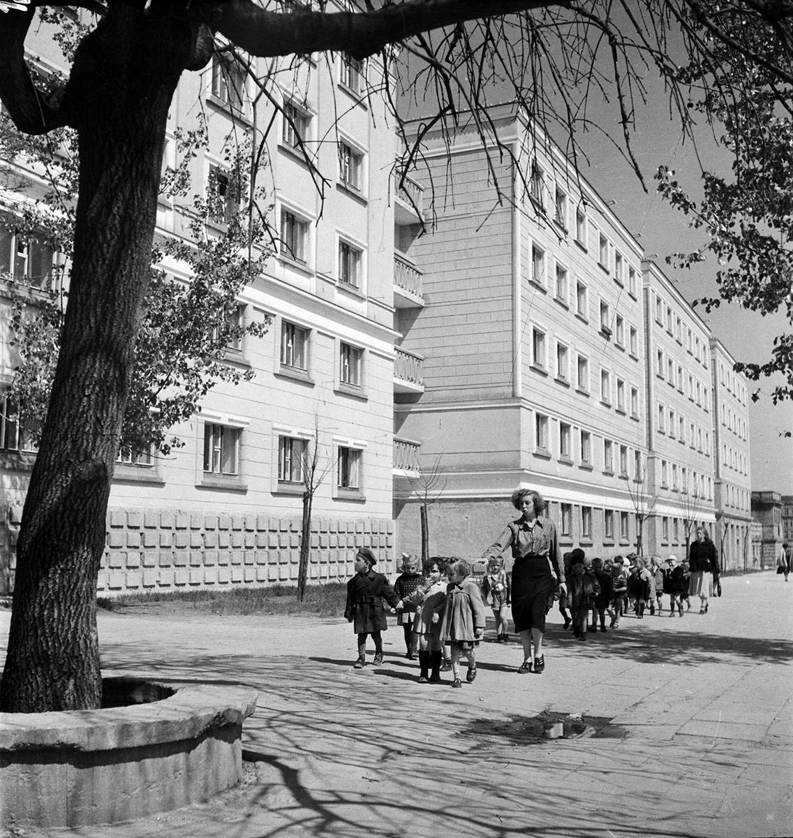 Warszawa 01.05.1952. Grupa przedszkolaków z opiekunkami idzie aleją Świerczewskiego (Solidarności). Widok w kierunku placu Dzierżyńskiego (Bankowy), z lewej powojenne bloki osiedla Muranów Południowy (Świerczewskiego 72), fot.PAP