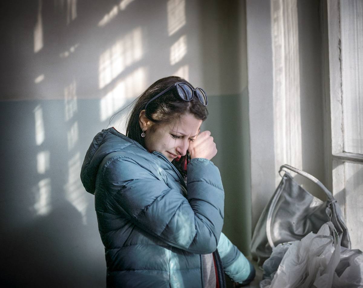Luty 2015 r., Kijów: Anna płacze na klatce schodowej wojskowego szpitala. Pracowała jako menedżerka w branży turystycznej. Kiedy rozpoczęła się wojna, poświęciła cały swój czas żołnierzom przebywającym w szpitalu wojskowym, w którym pracowała jako wolontariuszka (fot. Justyna Mielnikiewicz)