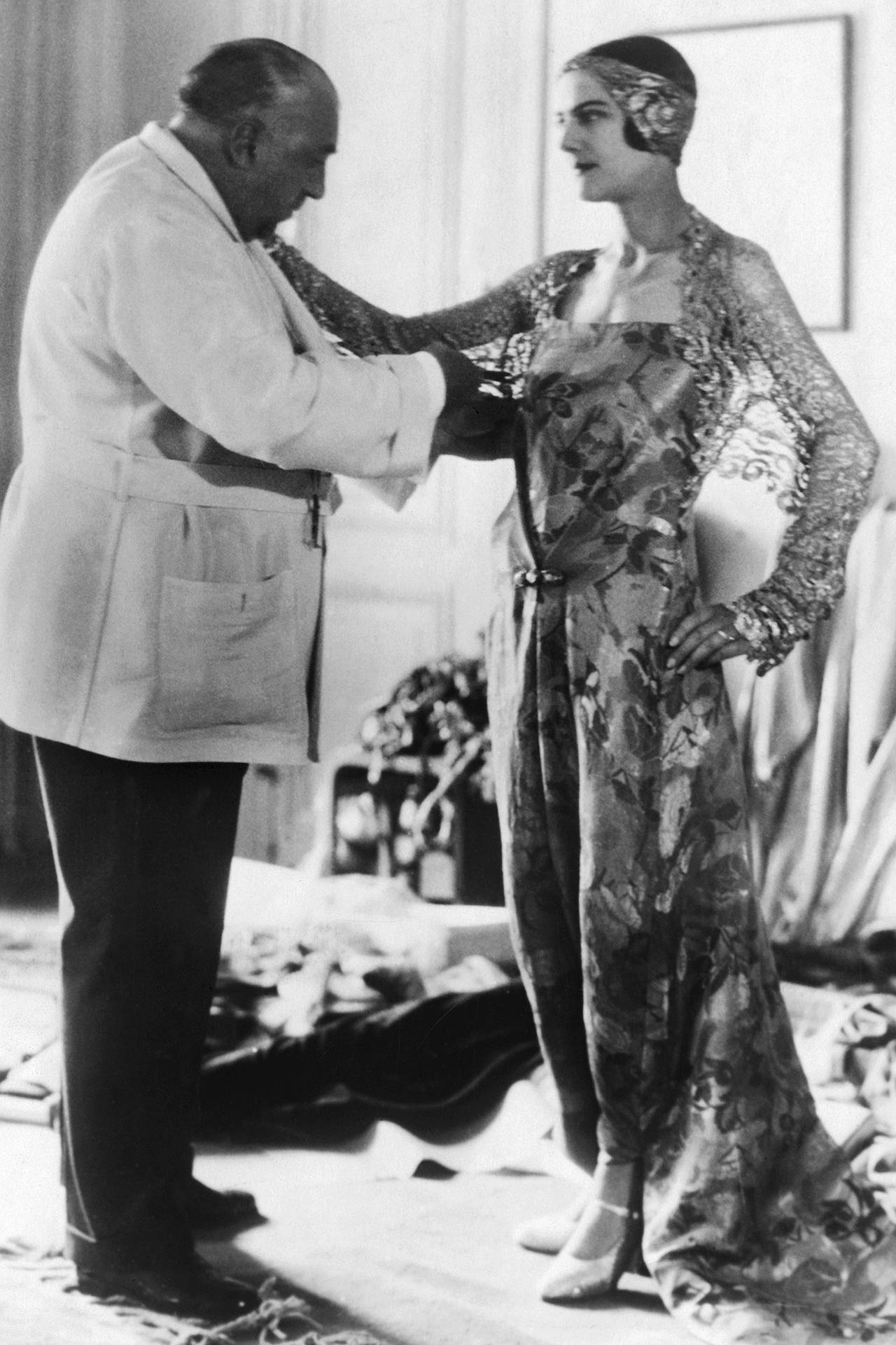 Paul Poiret w czasie przymiarek z modelką w Stanach Zjednoczonych, około 1930 roku / (Fot. George Rinhart/Getty Images)