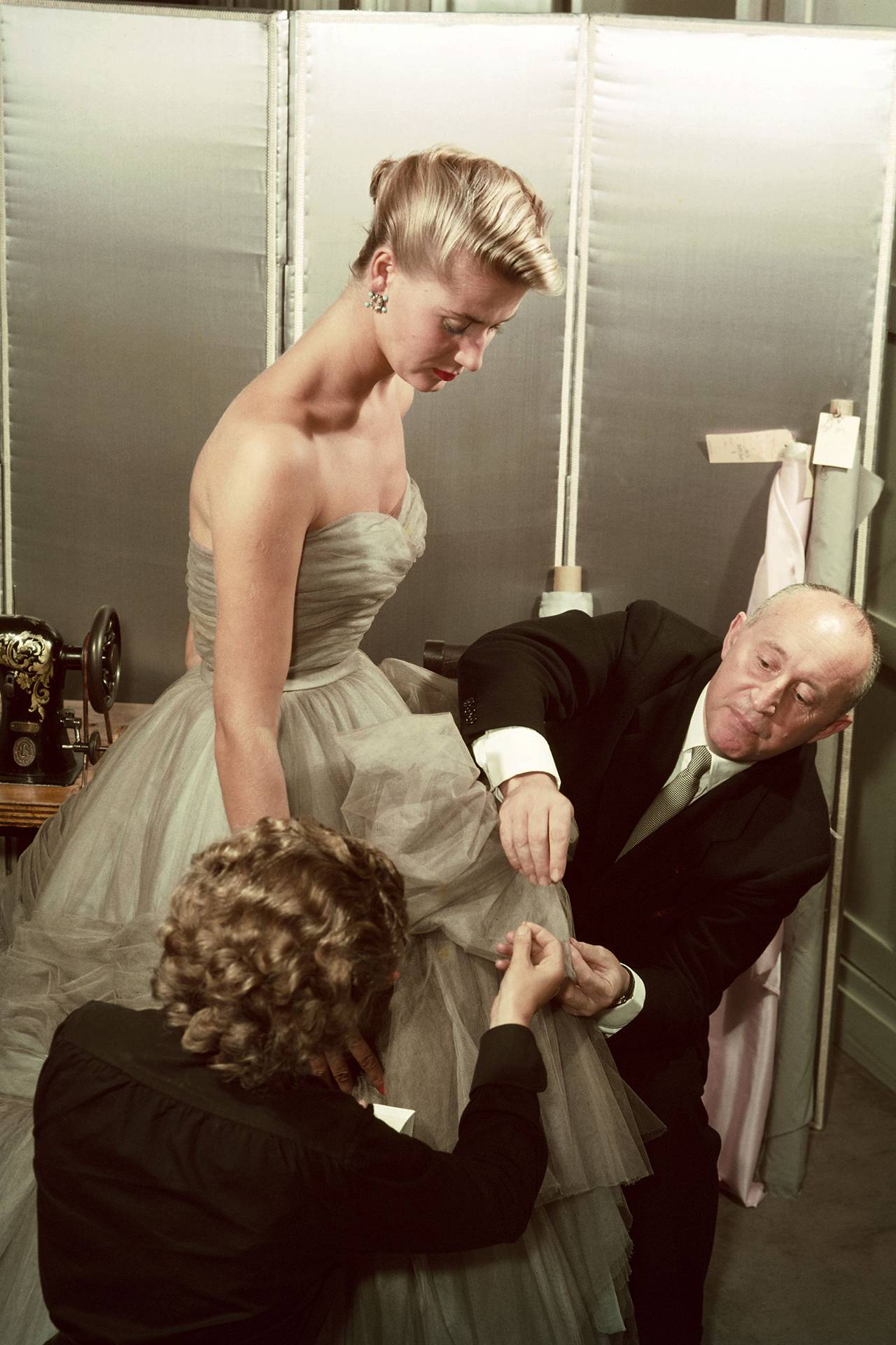 Christian Dior w czasie przymiarek szyfonowej sukni na modelce w swoim atelier, około 1950 roku / (Fot. Getty Images)