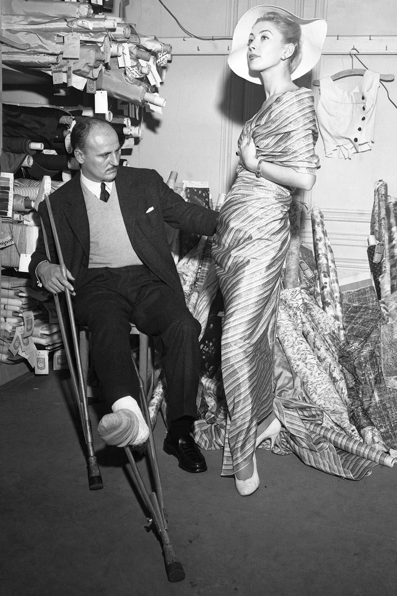 Z nogą w gipsie po wypadku na nartach Pierre Balmain przygotowuje się do wiosennego pokazu, 1955 rok (Fot. Getty Images)