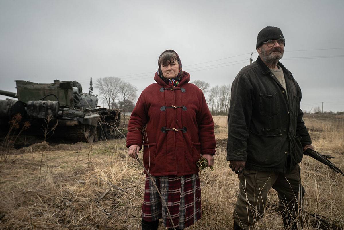 Maria z mężem obok domu i zniszczonego rosyjskiego czołgu. Podczas okupacji 15 rosyjskich żołnierzy weszło do ich domu, gdzie żyli przez 3 dni. 31.03.2022 region Czernihowa (fot. Patryk Jaracz)