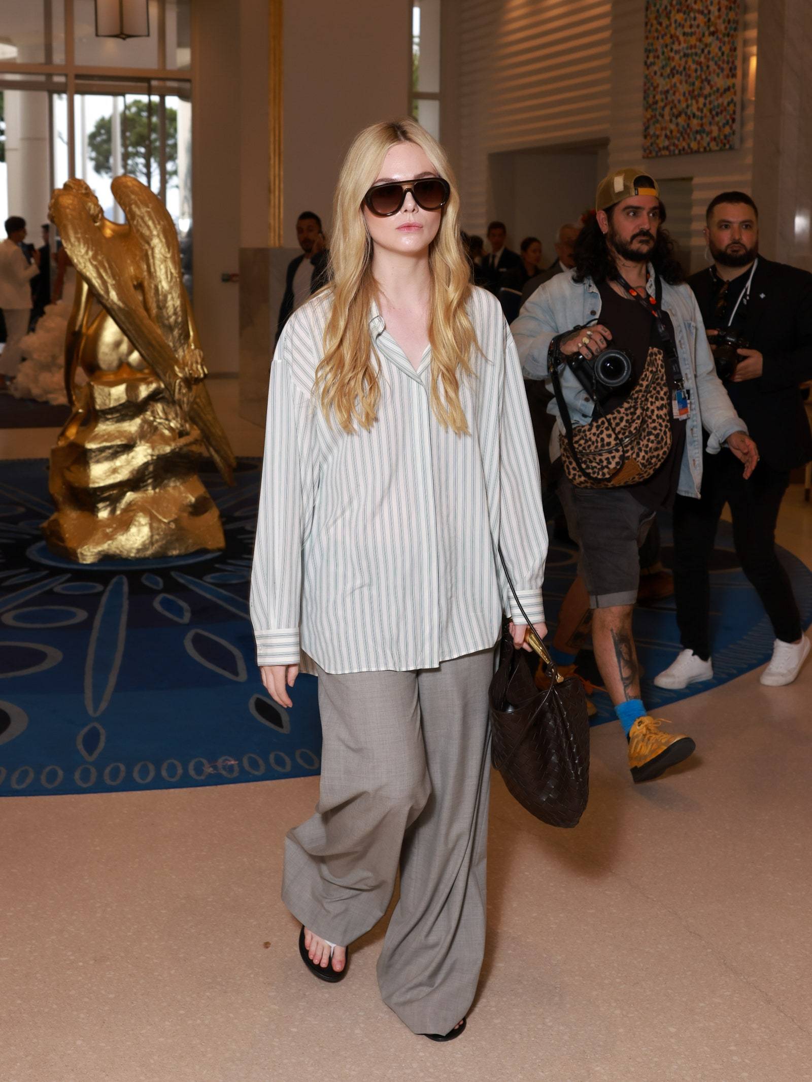 Elle Fanning demonstruje „teorię źle dobranych butów”, nosząc eleganckie spodnie z klapkami w Cannes. (Fot. Getty Images)
