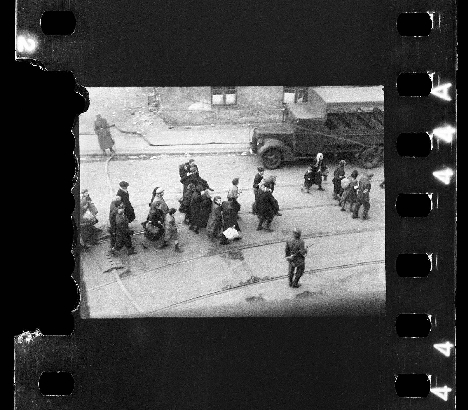 Żydzi prowadzeni na Umschlagplatz, zdjęcie zrobione przez okno szpitala św. Zofii, u zbiegu ul. Żelaznej i Nowolipie, wychodzące prawdopodobnie (to jeszcze do potwierdzenia) na ul. Nowolipie, komentarz autora zdjęcia zapisany po wojnie na rewersie odbitki, przechowywanej w archiwum USHMM w Waszyngtonie:  „Sceny z ewakuacji getta ok. 20.4.1943”Fot. Z. L. Grzywaczewski / z archiwum rodzinnego Macieja Grzywaczewskiego, syna Leszka Grzywaczewskiego 