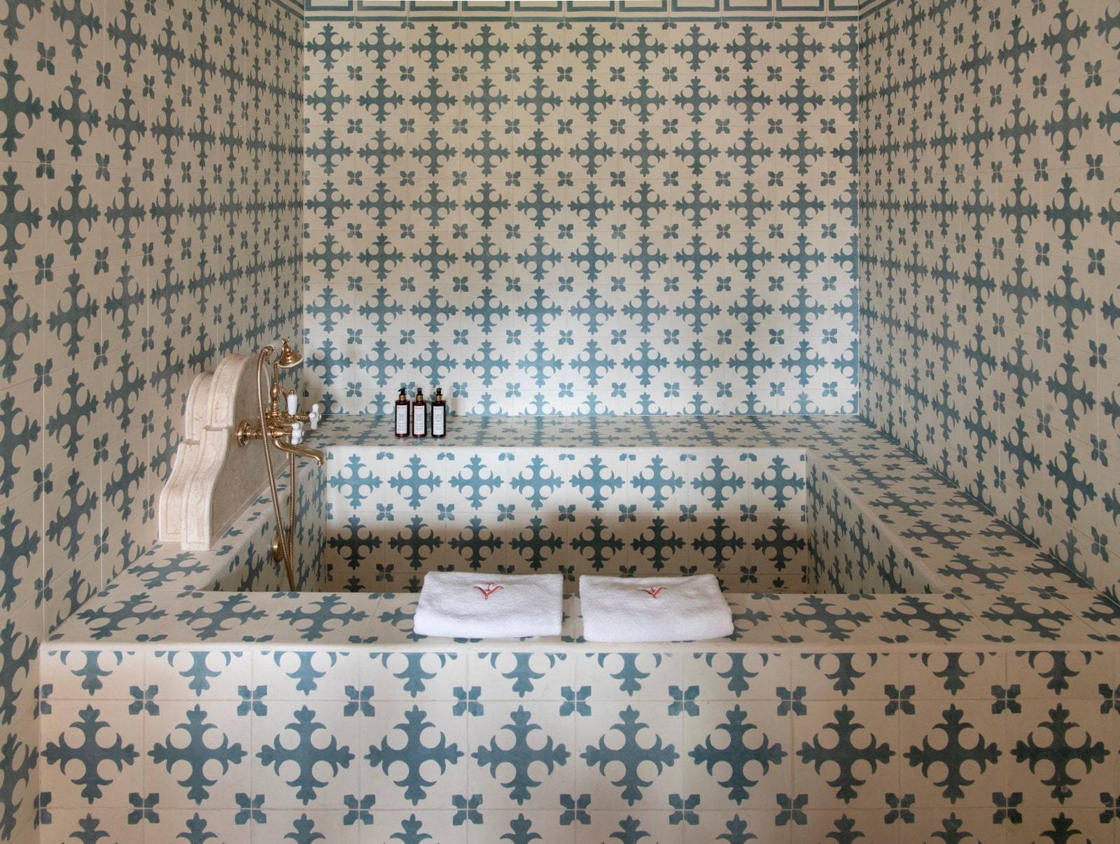 Wyłożona płytkami łazienka w jednym z apartamentów ogrodowych na parterze. (Fot. Ambroise Tézenas)