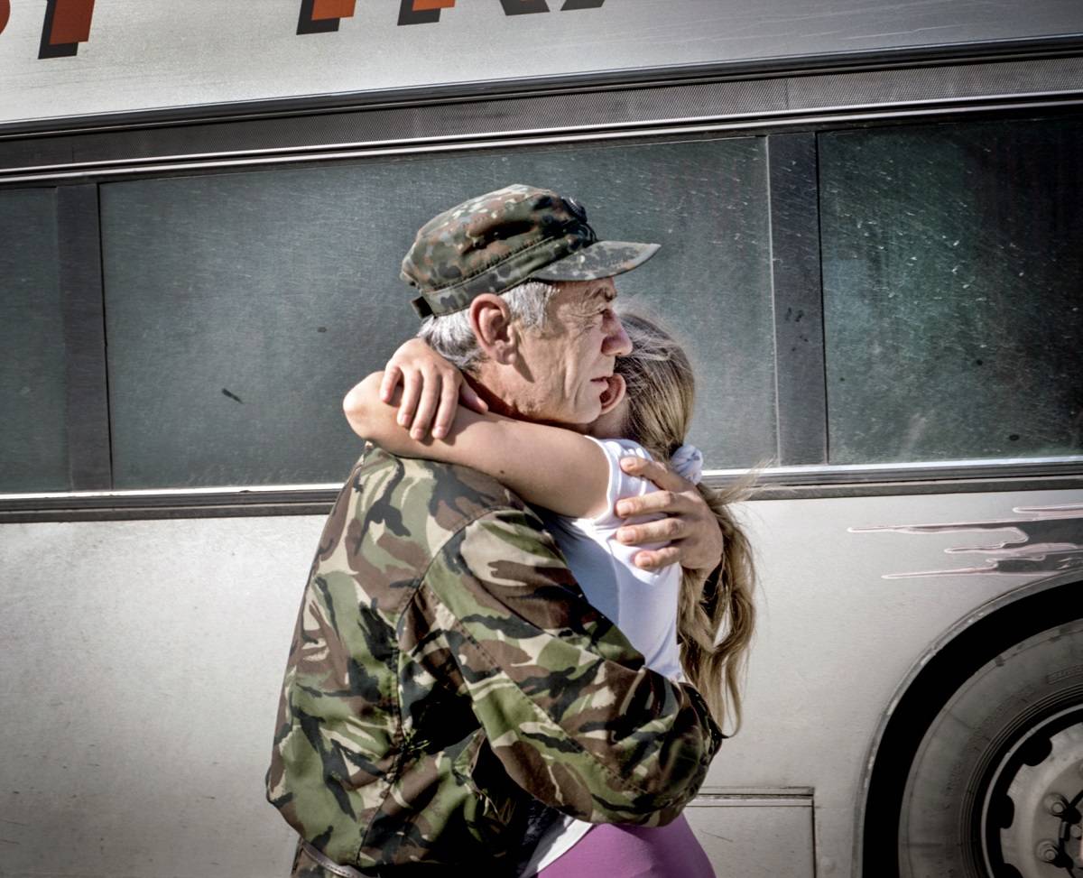 Lipiec 2015 r., CzerkasyKapitan Nikołaj Wasiliewicz Kasjanenko przytula córkę po powrocie do domu z linii frontu, gdzie spędził rok