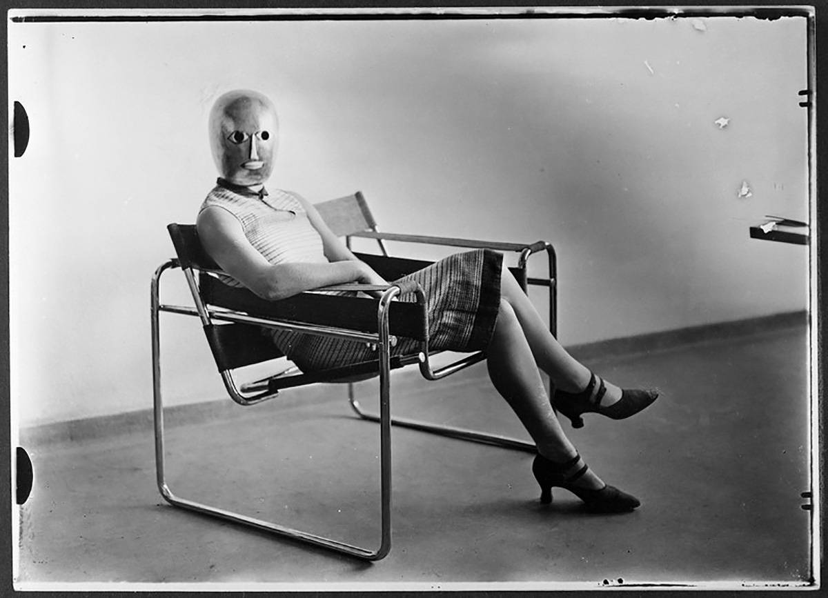 Kobieta w masce Oskara Schlemmera, siedząca na krześle Marcela Breuera, 1926 rok