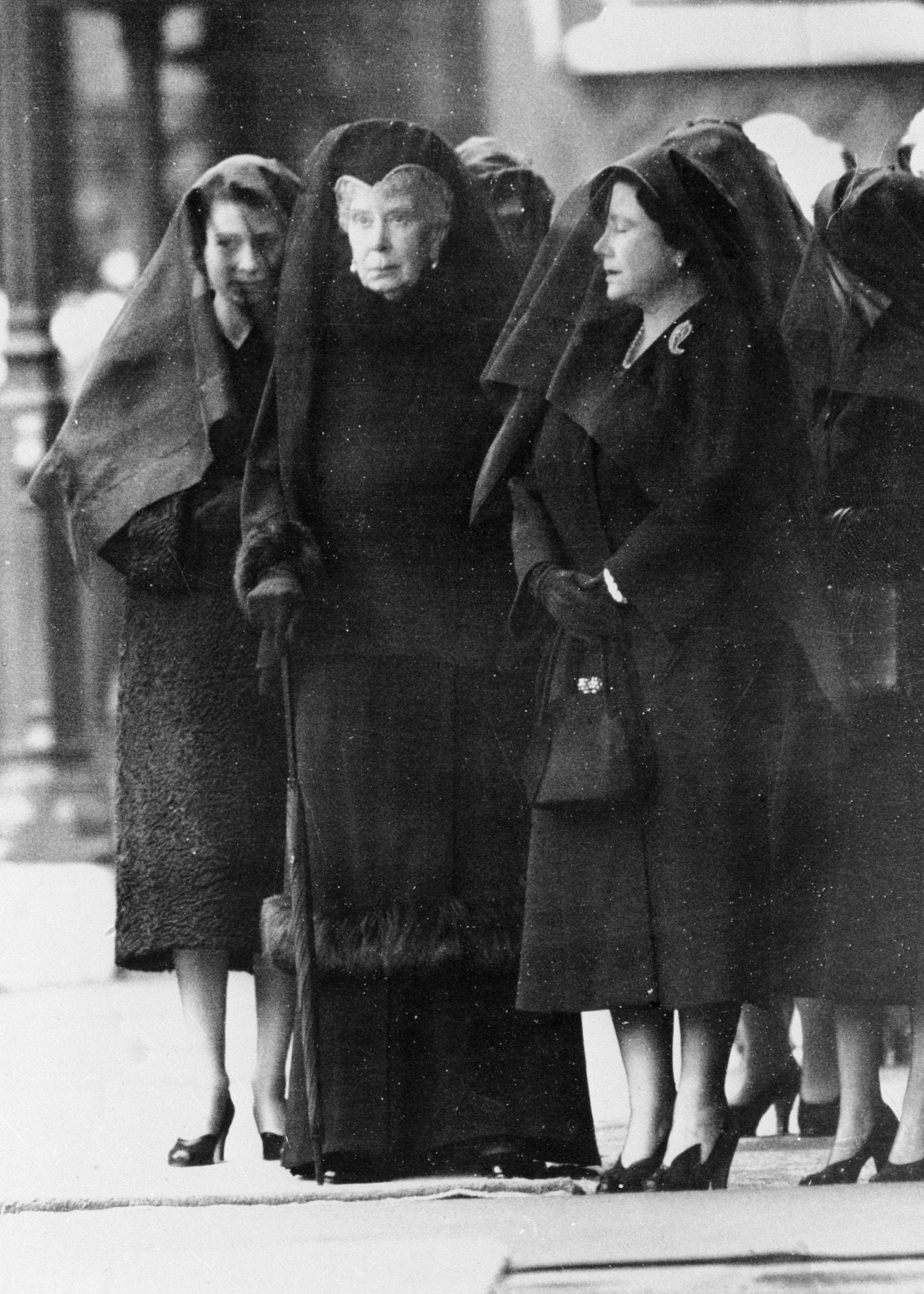 Królowa Elżbieta II, królowa Maria i królowa Elżbieta (królowa matka, wdowa po królu Jerzym VI) – wszystkie w czarnych żałobnych strojach i perłach oczekujące na przyjazd specjalnego pociągu, który w lutym 1952 r. przywiózł trumnę Jerzego VI z Sandringham przed jego pogrzebem. (Fot. Getty Images)