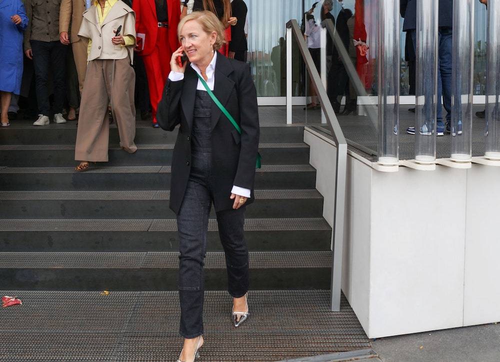 Uliczny styl Mediolanu proponuje eleganckie zestawienie jeansowych ogrodniczek z klasyczną marynarką damską (Fot. Phil Oh)